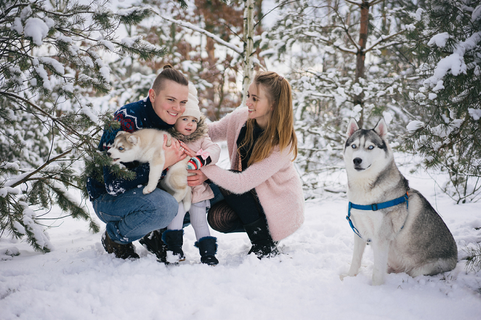 family with dog posing in the snow
